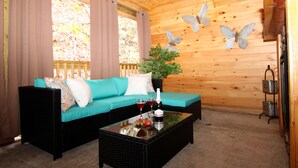 A wooden interior with a teal sofa, black coffee table, and butterfly wall decorations. - Gatlinburg Cabin Free Tickets, Heart Whirlpool, Hot Tub, King Bed, Fast Internet (Gatlinburg)