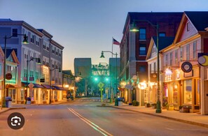 A street view of a town with buildings on both sides, a pedestrian crossing, and a traffic light. - Mystic Home perfect for families- Easy walk to downtown. . (Mystic)