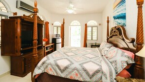 Quarto com uma cama grande, móveis de madeira e um ventilador de teto.