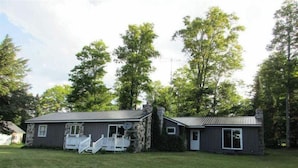 A two-story stone house with a porch and a small attached garage.