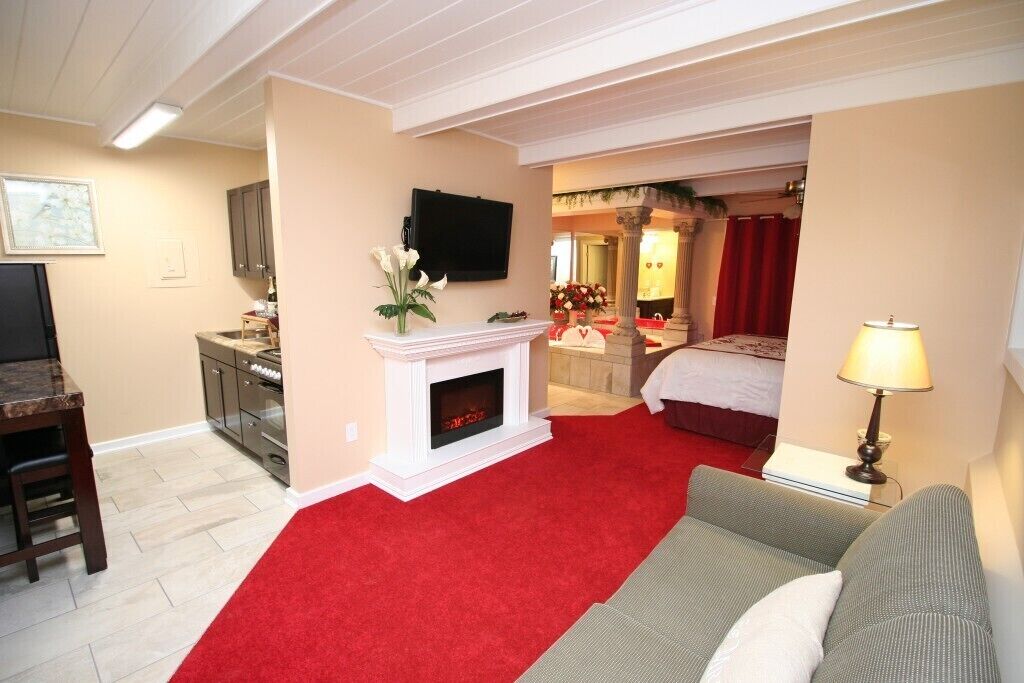 Une chambre d’hôtel équipée d’une cheminée, d’une télévision, d’un coin repas et d’un lit.