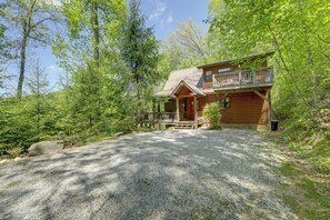 A wooden cabin with a balcony, surrounded by trees and a gravel driveway. - Hot Tub, Fire Pit & Mtn Views: Bryson City Escape (Bryson City)