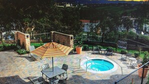Une terrasse extérieure avec une piscine, des sièges et une vue sur le paysage.