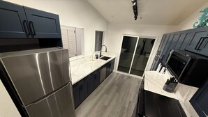 Une cuisine moderne dotée d’appareils électroménagers en acier inoxydable, de meubles de couleur sombre et d’un plan de travail en marbre.