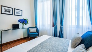 A hotel room with a bed, a desk with a laptop, a chair, and a window with curtains. - Ca' Del Monastero 1 Collection with Balcony (Venice)