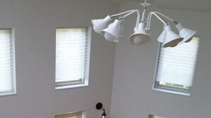 A spacious room with a wooden staircase, multiple windows, and a ceiling light fixture. - Seolrem 9 (Yangyang)
