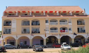 A multi-story building with a tiled roof, multiple balconies, and a ground-level entrance labeled "RESTAURANT."