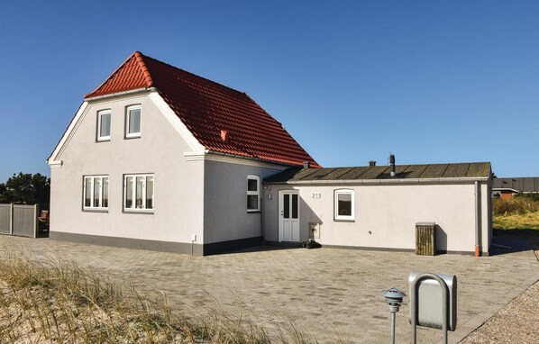 Stylish two-story home with a main house and attached garage, featuring a large front door and multiple windows.
