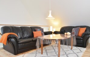 Relax in this inviting living space with a comfortable sofa, coffee table, and plush cushions.
