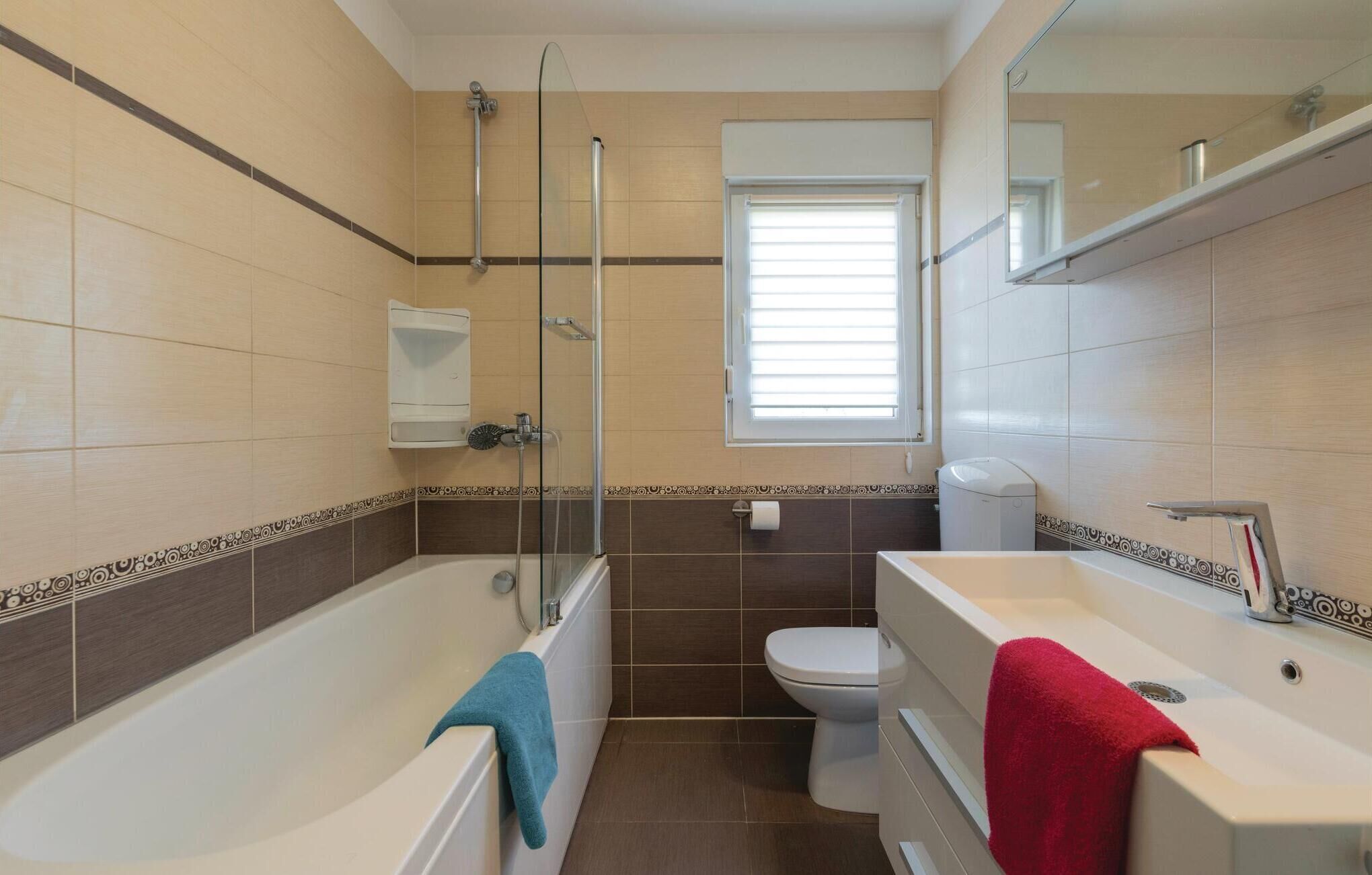 Un bagno con vasca, water e finestra.