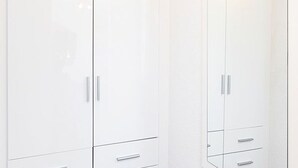 Un armario blanco con dos puertas y dos cajones.