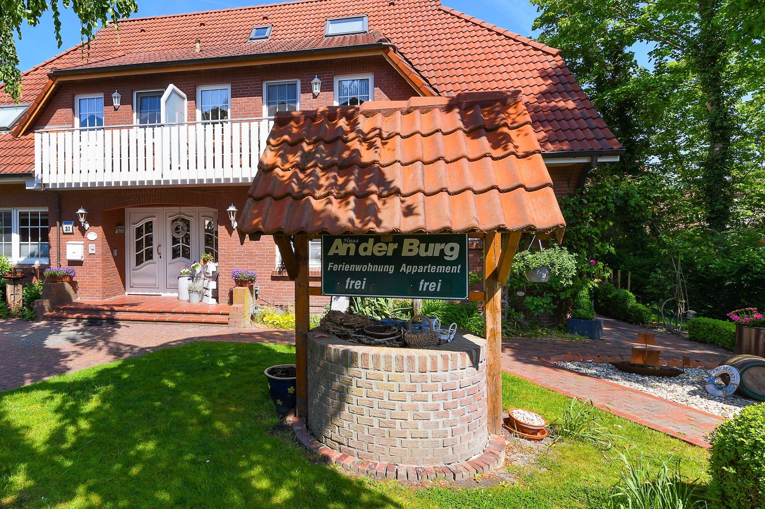 Ein Backsteinhaus mit Balkon und einem Schild, auf dem steht: 'Ander Burg Ferienwohnung Appartement frei.'