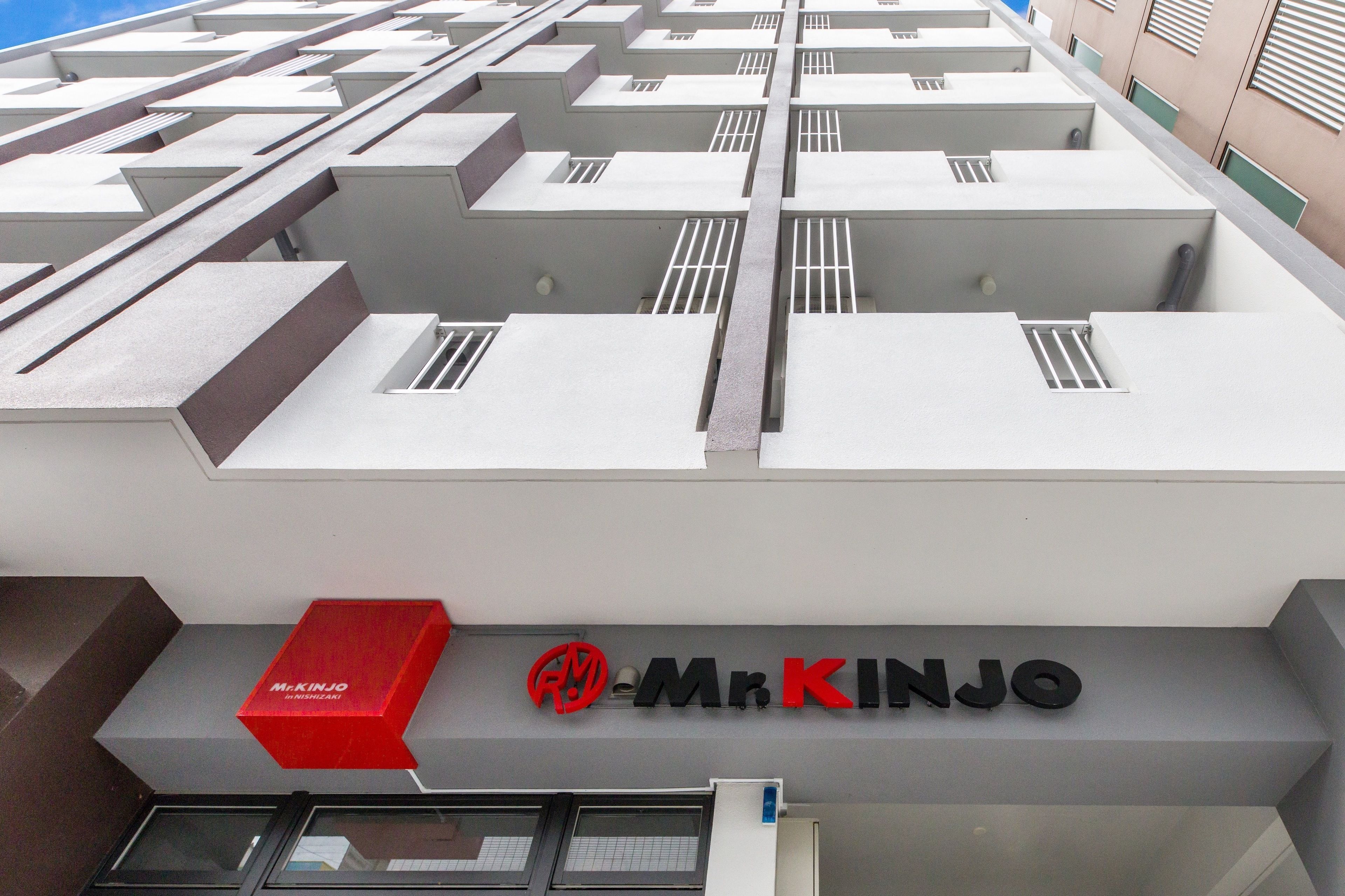 A modern building with a geometric facade and a prominent 'Mr. Kinjo' sign.