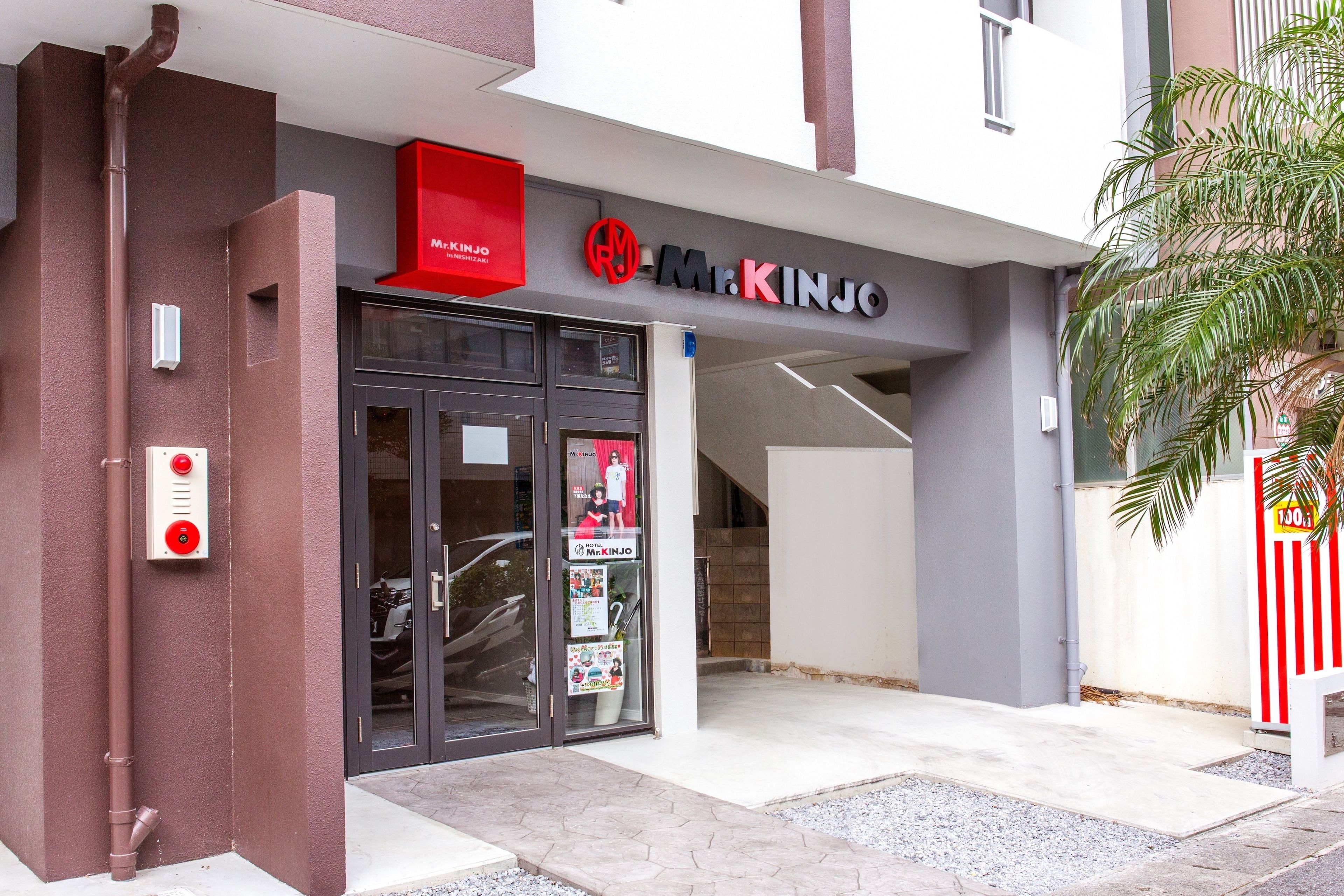 A building entrance with a sign reading "Mr. Kinjo" and a red mailbox.