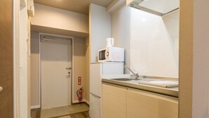 Eine kompakte Küche mit Mikrowelle, Spüle und Feuerlöscher.
