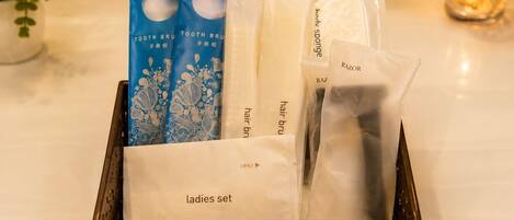 A tray containing a ladies set with a toothbrush, hair brush, and razor.