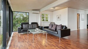 Un salon moderne avec deux canapés, une table basse en verre et un plancher en bois.