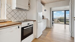Une cuisine moderne avec des meubles blancs, un lave-vaisselle Bosch et un four encastré.