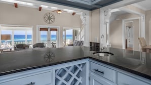 Een moderne keuken met een groot eiland, uitzicht op de oceaan en een eetgedeelte met uitzicht.