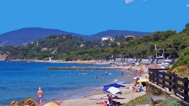 A beach with people swimming and sunbathing, a clear blue sky, and mountains in the background. - Charming 3-Bedroom Mas with Garden, Pool, Tennis & 1.5km to Beach in La Croix-Valmer (La Croix-Valmer)