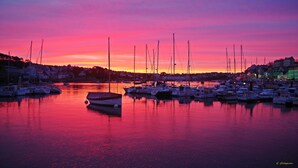 Un puerto deportivo con barcos amarrados al atardecer.