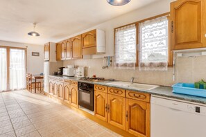 A kitchen with wooden cabinets, a gas stove, a dishwasher, and a sink.
