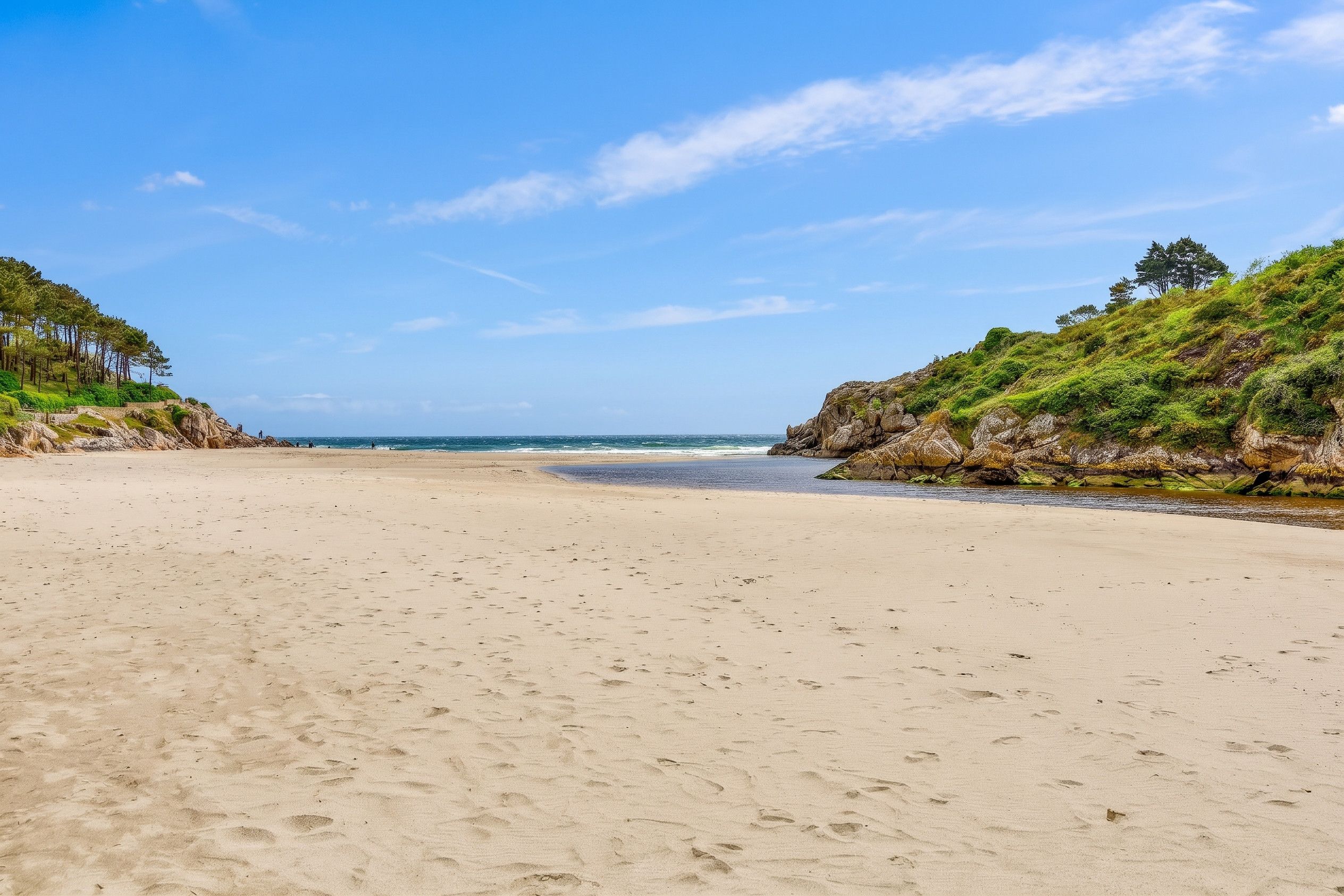 A sandy beach with a clear sky and calm sea.