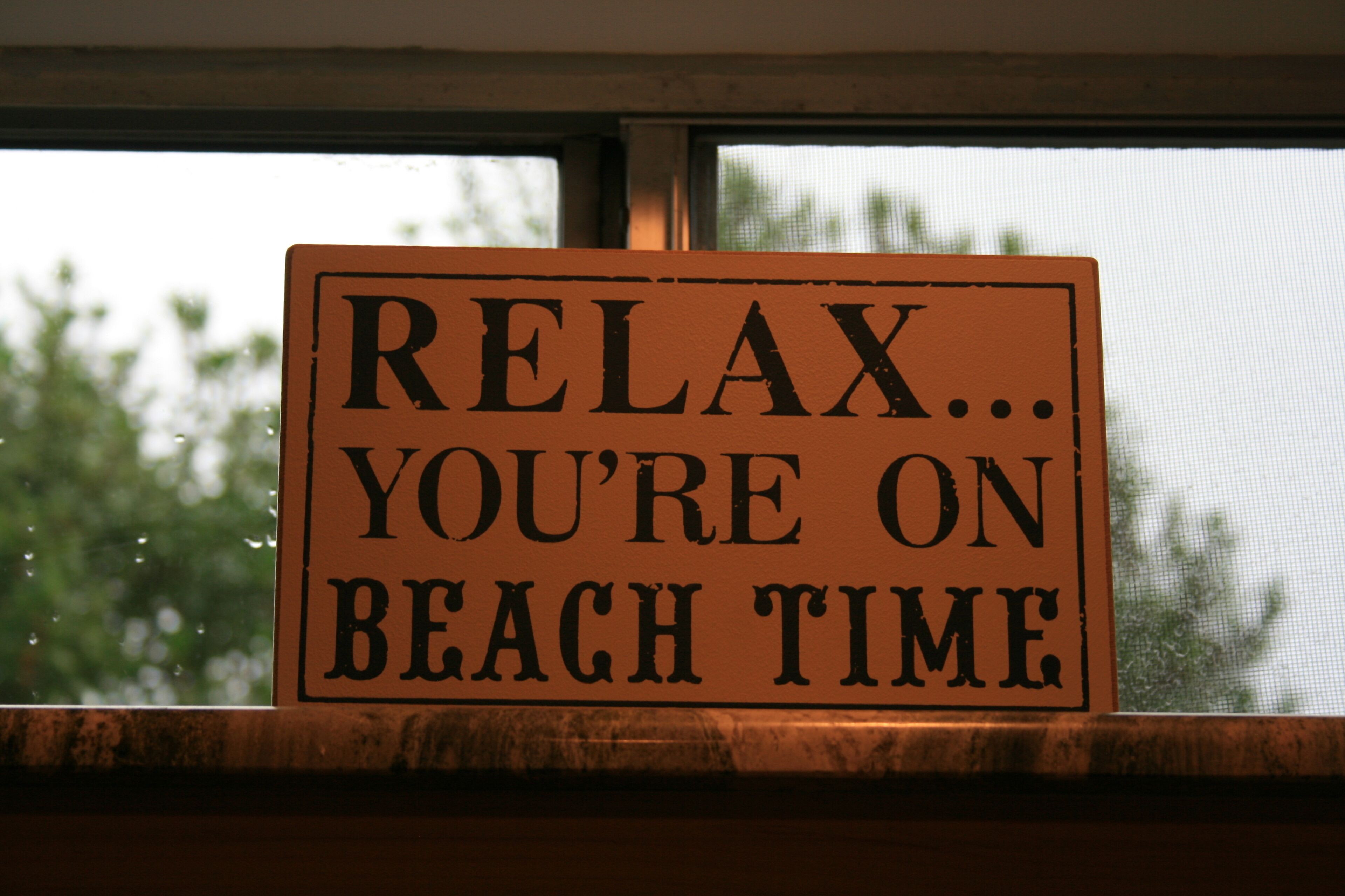 Ein Schild an einem Fensterbrett mit dem Text: RELAX... SIE SIND IM URLAUB.