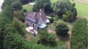 A house surrounded by dense greenery, with a visible patio area and a swimming pool in the background. - Your holidays in a beautiful property (Varaville)