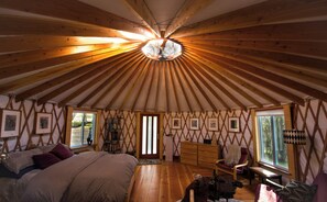 A spacious room with a high ceiling and wooden beams, a bed, a desk, and a chair. - Very Sexy, Cozy and Romantic! Located Near Yosemite/Bass Lake (Oakhurst)