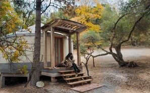 A rustic wooden structure with a bench and a small table, surrounded by trees and a dirt ground. - Very Sexy, Cozy and Romantic! Located Near Yosemite/Bass Lake (Oakhurst)
