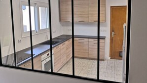 A modern kitchen with wooden cabinets, a black countertop, and a built-in oven.