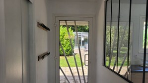A hallway with a glass door leading to an outdoor area.