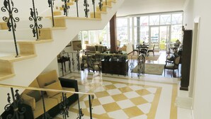 A spacious living area with a checkered floor, a staircase with ornate railings, and a view through large windows. - villa in the center of Funchal with pool and garden (Funchal)
