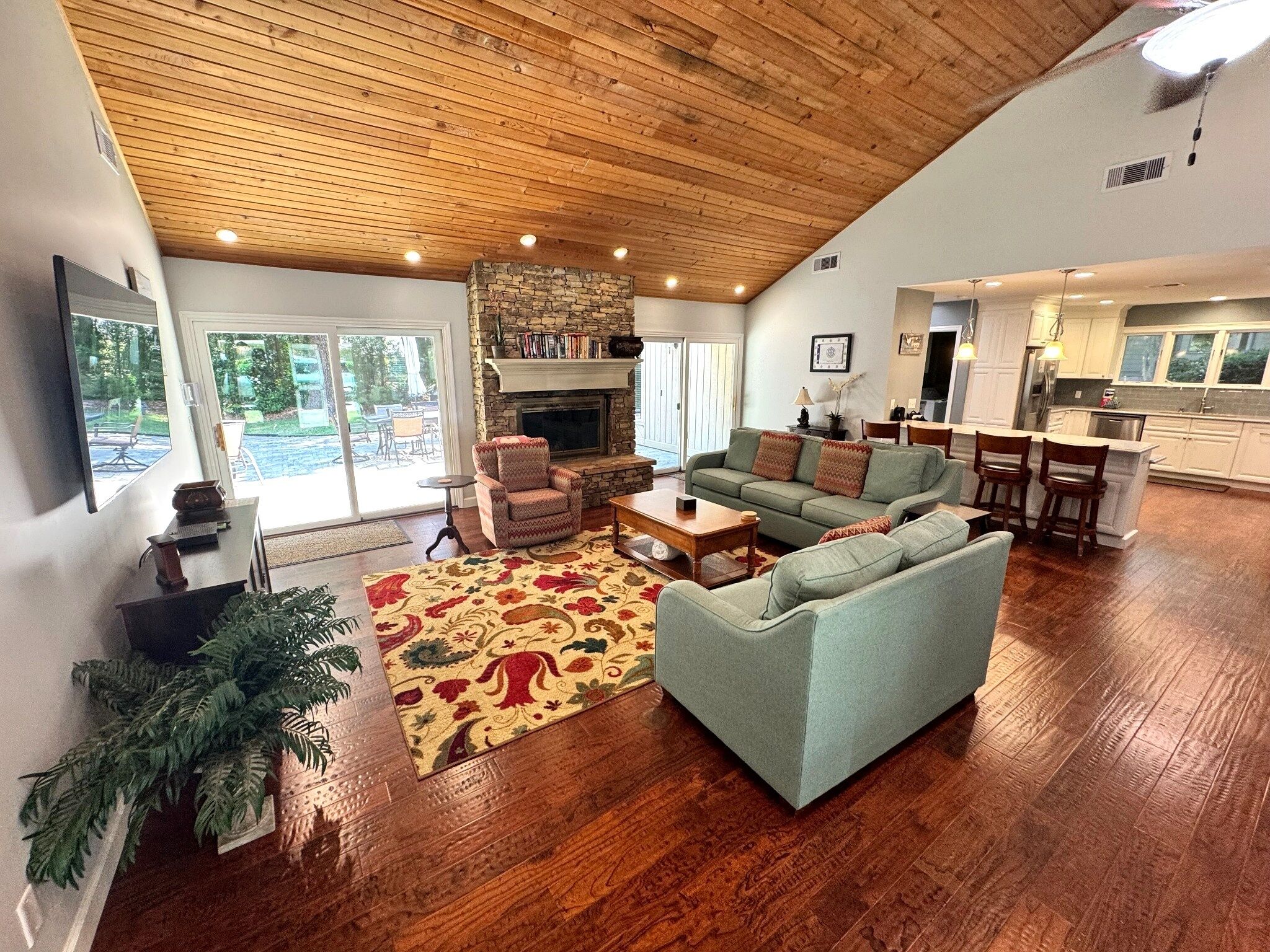 A spacious living room with a fireplace, a dining area, and a kitchen.