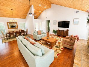A spacious living room with a large sofa, a coffee table, and a television.