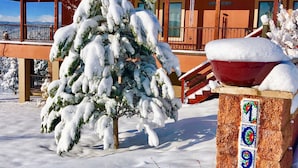 A snow-covered building with a balcony and a tree in front. - Large downstairs rental.1 bedroom.Full size kitchen.walk in shower No sharing  (Ruidoso)