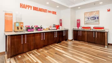 A breakfast area with a sign reading 'HAPPY BREAKFAST STARTS HERE.'