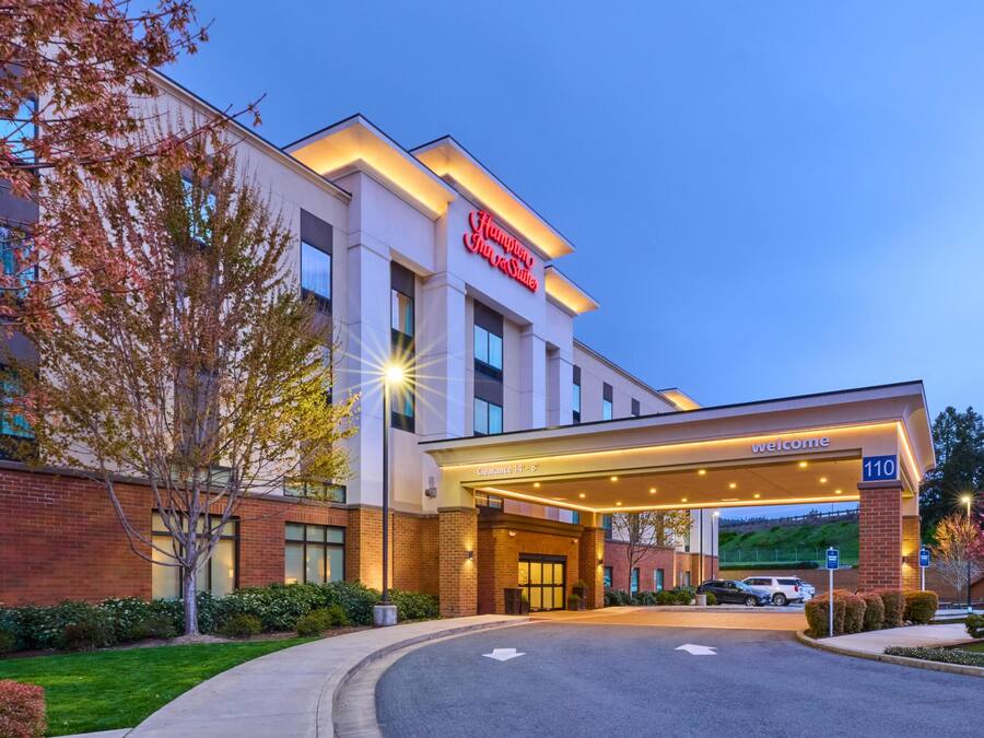 A Hampton Inn & Suites hotel entrance with a clearway sign, brick facade, and a welcoming entrance.
