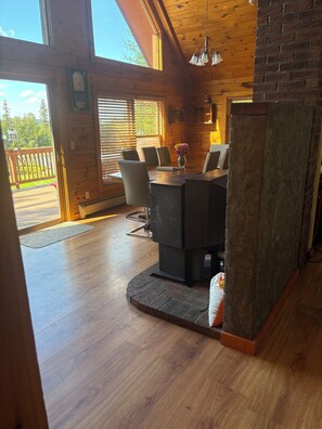 Un accogliente interno di una baita con un tavolo da pranzo in legno, sedie e un camino.