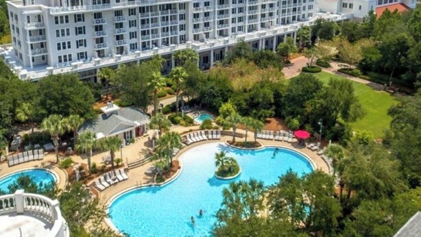 A large hotel with multiple floors, a central courtyard with a swimming pool, and surrounding greenery. - Enjoy your very own private courtyard! FREE TRAM ! Mins. to pool,dining,shopping (MIRAMAR BEACH)