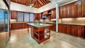 Una cocina amplia con armarios de madera, una isla central y un ventilador de techo.