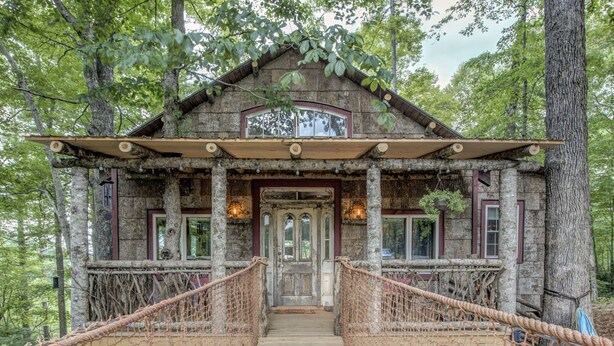 A rustic cabin with a wooden deck and rope bridge, surrounded by trees. - TREE HOUSE on Little Peak Creek Farm! (Jefferson)