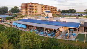 A hotel with outdoor seating areas, a pool, and a restaurant.