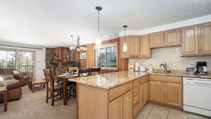 A spacious kitchen with wooden cabinets, a granite countertop, and a dishwasher.