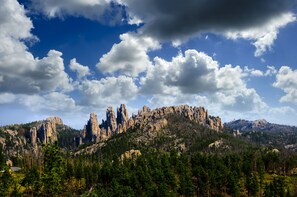 A mountainous landscape with rocky formations and dense forest.