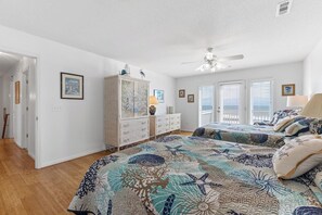 A bedroom with two beds, a dresser, and a ceiling fan. - ☀️Casablanca: Oceanfront Home w/ Ocean Views☀️ (Kure Beach)