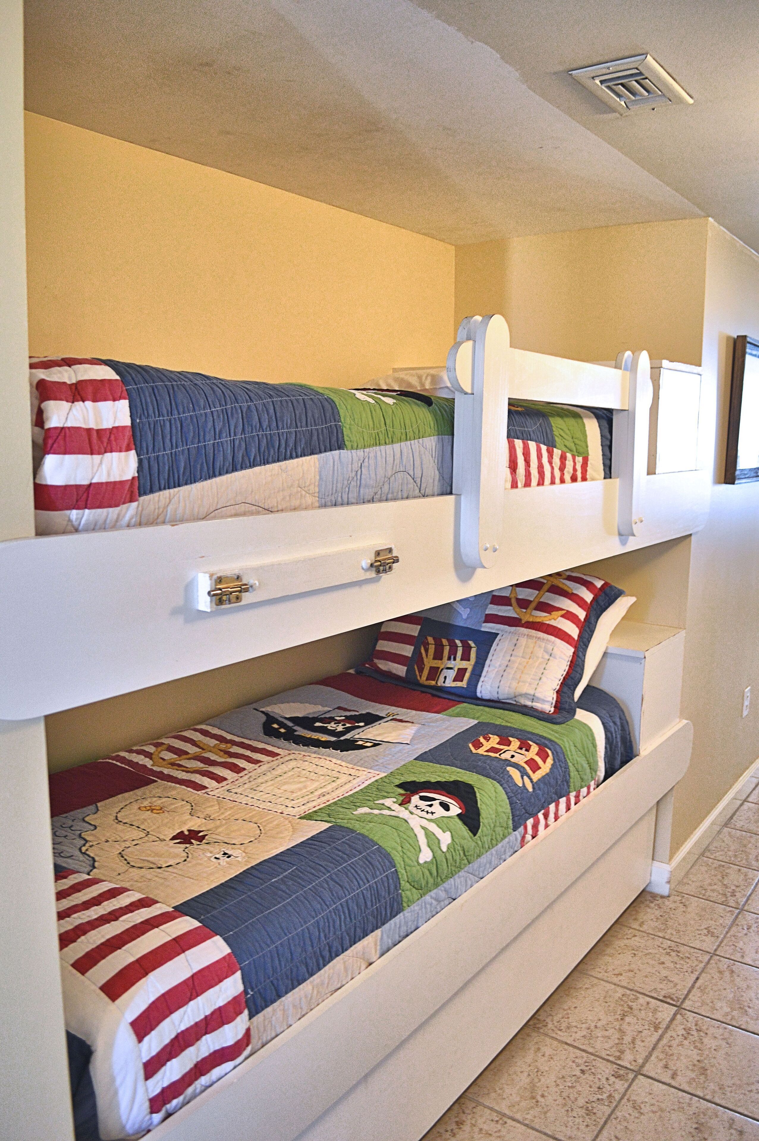 A bunk bed with two levels, each with a mattress and pillows.