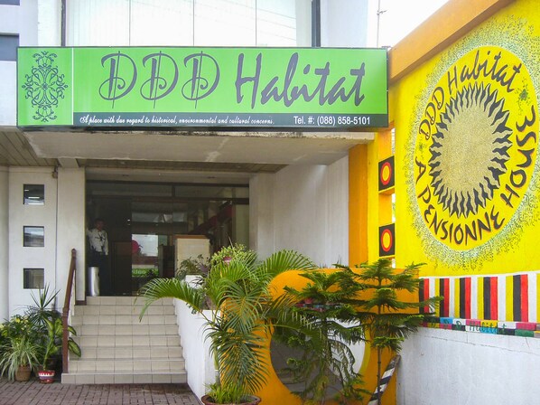 A hotel entrance with a green sign reading "DDD Habitat" and a yellow mural with "Habitat Pension House" text. - Ddd Habitat Pension House (Cagayan de Oro)