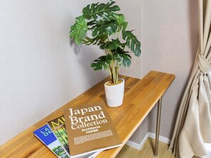 A wooden console table with a potted plant and a book titled "Japan Brand Collection Architects TOP50". - Mr.KINJO in ASATO (Naha)